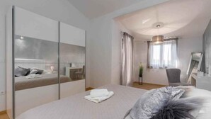 Ein modernes Schlafzimmer mit einem großen Bett, einem Schreibtisch und einem Spiegel.