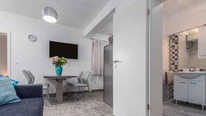 Ein modernes Apartment mit Wohnzimmer, Essbereich und Küche.