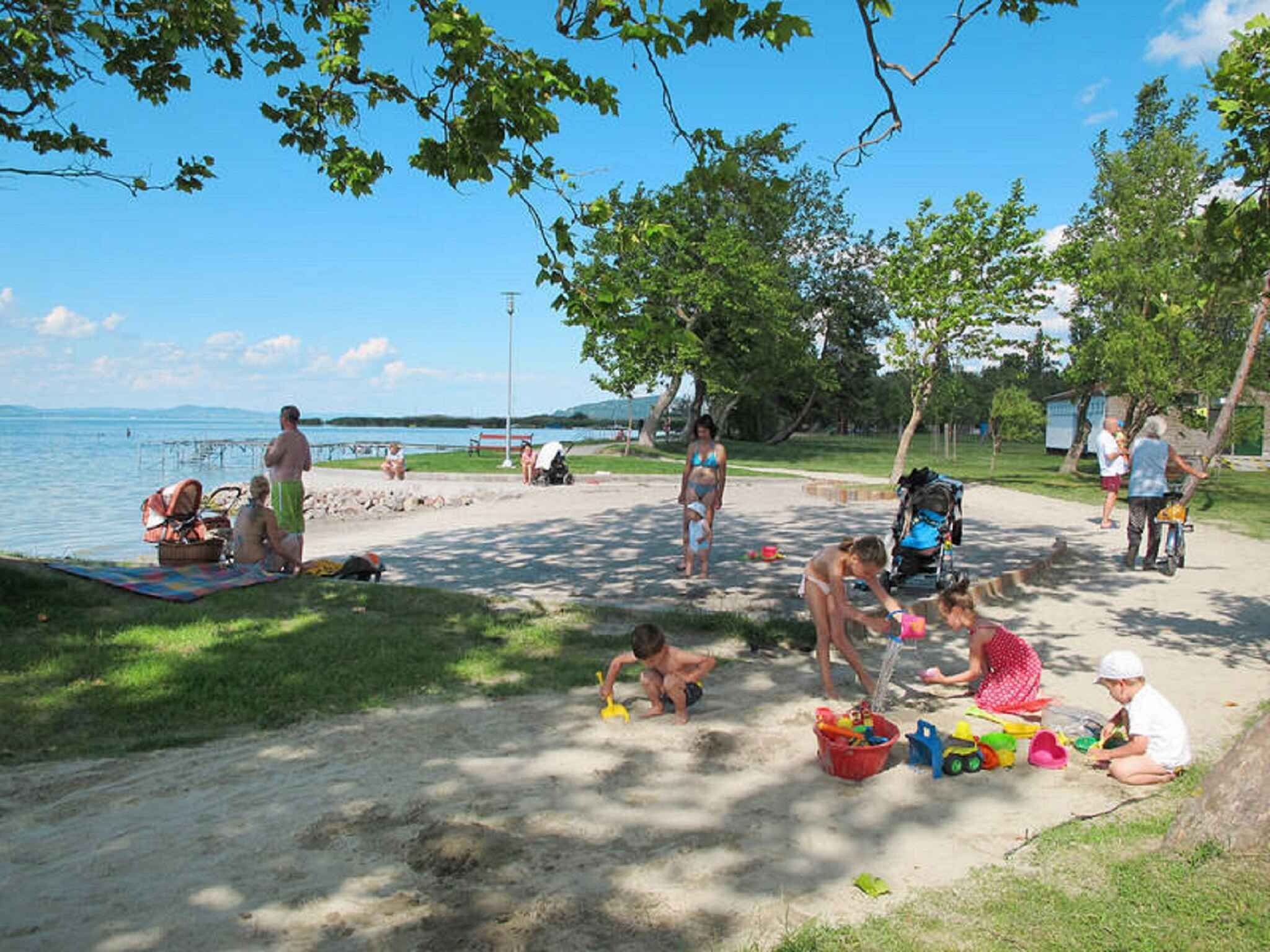 Een strandscène met mensen die ontspannen en kinderen die spelen.