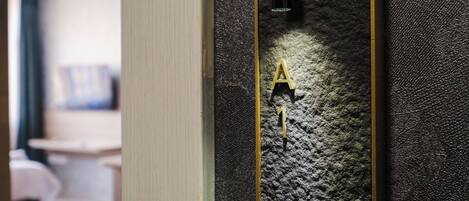 A textured wall with a golden number '1' and a black light fixture.