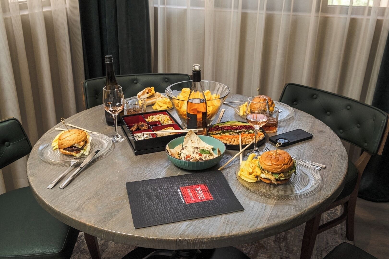 A round dining table with various dishes, drinks, and utensils.