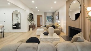 Un salon moderne avec un canapé, une table basse et une cheminée.