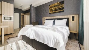 Une chambre d’hôtel moderne équipée d’un grand lit, d’un bureau et d’un four à micro-ondes.