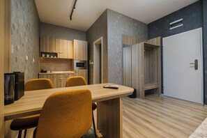 A modern kitchen with wooden cabinets, a built-in microwave, and a coffee machine.