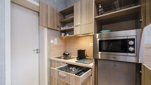 Uma cozinha compacta com armários de madeira, micro-ondas embutido e uma pia.