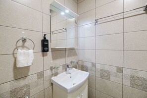 A modern bathroom with a white sink, a towel rack, a soap dispenser, and a mirror. - А17 Plovdiv Apartments Next to RowingChannel app7 (Plovdiv)
