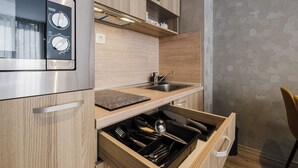 A modern kitchen with wooden cabinetry, a built-in oven, a sink, and a dishwasher drawer.