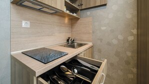 Une cuisine moderne avec des meubles en bois, un évier en acier inoxydable et un bloc à couteaux encastré.