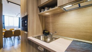 A modern kitchen with a stainless steel sink, wooden cabinetry, and a built-in microwave.