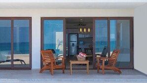 A modern two-story building with a balcony, large glass doors, and a pool. - Ocean Heaven: New Downtown Condo (Isla Mujeres)