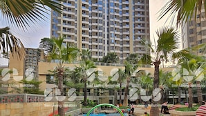 A residential complex with high-rise buildings, a central water feature, and palm trees. - Hava By SanLiving - 1 BR - Taman Anggrek (Jakarta)