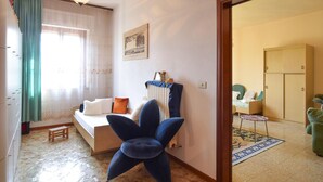 A cozy bedroom with a bed, a blue chair, a small table, and a wardrobe. - Beautiful home in Lari with outdoor swimming pool (Lari)