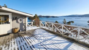 A wooden deck with snow, a white railing, and a view of a lake and mountains. - 3 bedroom beautiful home in Fjelberg (Fjelberg)