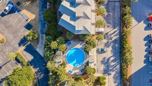 An aerial view of a hotel with a swimming pool, parking area, and surrounding greenery. - Private Beach Access-Pool-Central Destin BP1003 (Destin)