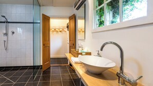 A modern bathroom with a freestanding bathtub, a large mirror, and a shower area.