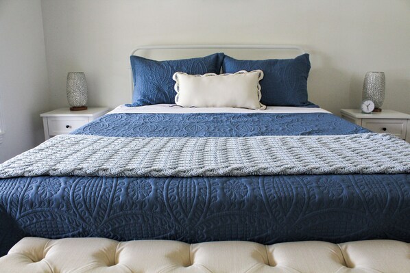 A bed with a blue quilt, white and blue pillows, and a white headboard. - Beautiful Riverfront Home on Medina River, sleeps 6 (Castroville)