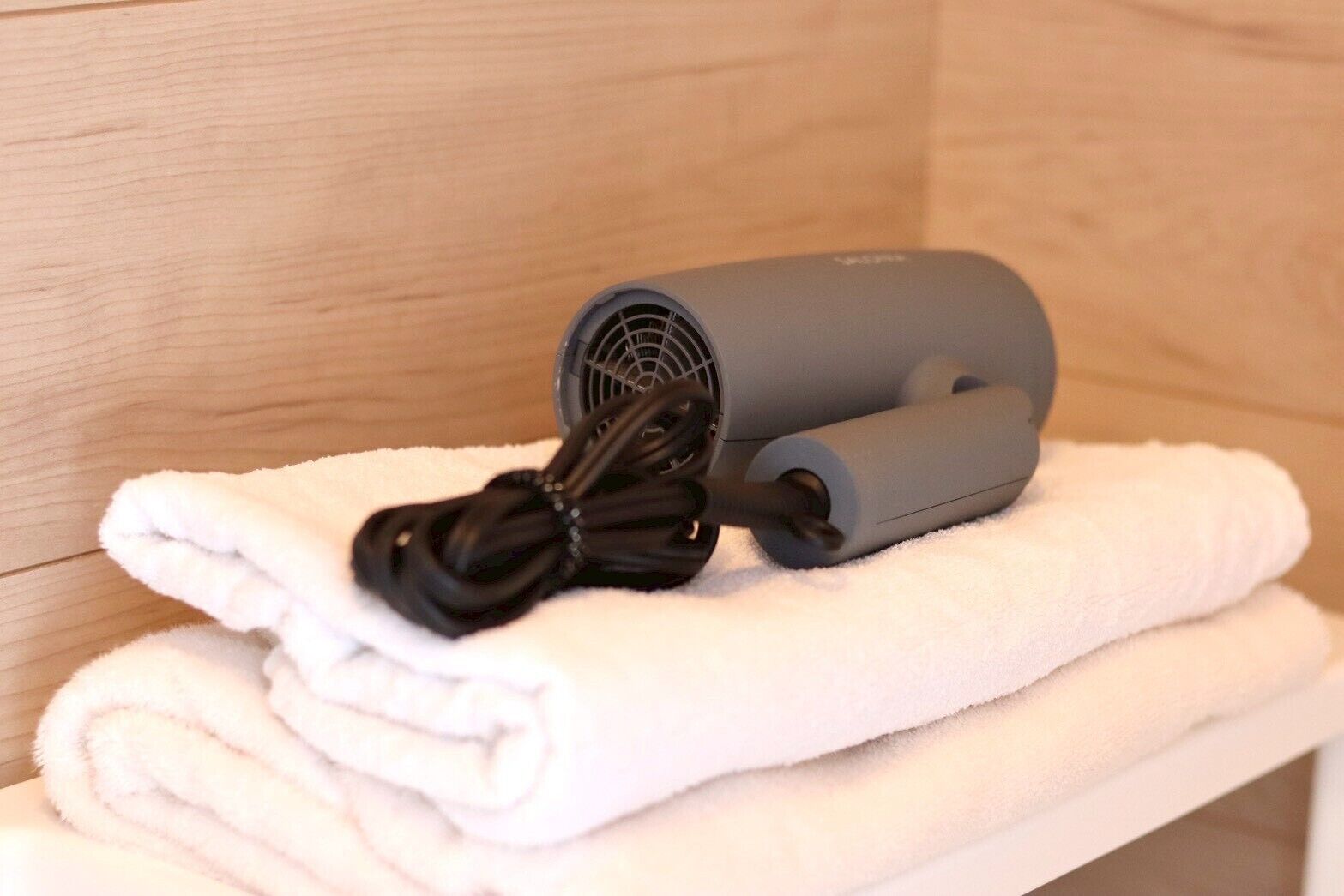 A hair dryer on a white towel in a bathroom.