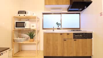 Een koelkast met diepvriezer, een microgolfoven, een oven, een kookplaat