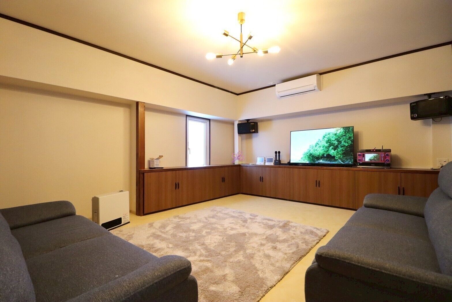 A living room with a large flat-screen TV, a fireplace, and a cozy seating area.