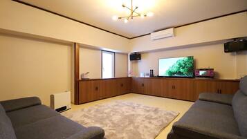 A living room with a large flat-screen TV, a fireplace, and a cozy seating area.