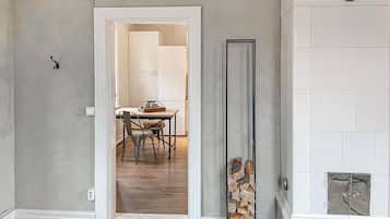 Un pasillo con una puerta blanca que da a un comedor con mesa y sillas.