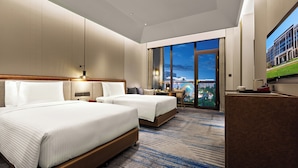 A hotel room with two beds, a desk, a chair, a TV, and a large window with a city view. - Wanda Vista Changchun International Movie Metropolis (Changchun)