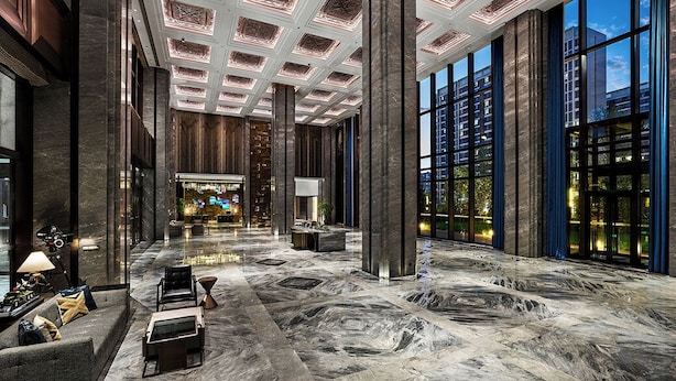 A spacious lobby with a high ceiling, large windows, and a central seating area. - Wanda Vista Changchun International Movie Metropolis (Changchun)