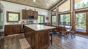 Una cocina amplia con armarios de madera, una isla grande y una zona de comedor con sillas.