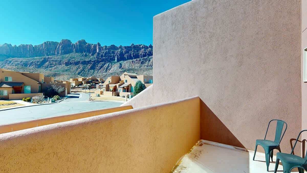 A balcony with a view of a desert landscape and buildings.