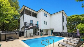 A two-story building with a swimming pool, outdoor seating, and a barbecue area. - Aqua Vie - 4 BR Retreat w/Private Pool, Hot Tub, Elevator (Southern Shores)