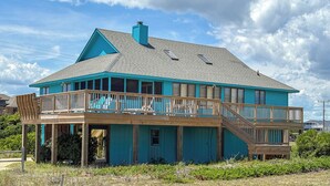 A two-story house with a balcony and a covered porch. - MacAllister - Semi-Oceanfront 3 BR Beach Bungalow - Dogs Allowed (Southern Shores)