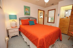 A bedroom with a bed, nightstand, dresser, and a window with blinds. - One Particular Harbour - 5 BR Single Level Ranch, Private Pool, Canalfront (Southern Shores)