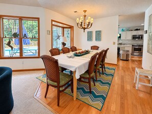 A dining area with a table set for six, surrounded by wooden chairs with cushioned seats. - One Particular Harbour - 5 BR Single Level Ranch, Private Pool, Canalfront (Southern Shores)