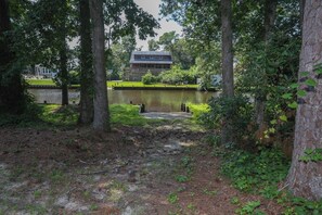 A serene lakeside setting with a dock leading to a house. - One Particular Harbour - 5 BR Single Level Ranch, Private Pool, Canalfront (Southern Shores)