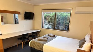 A hotel room with a bed, a desk, and a TV. - Cosy Queen Room Charleville (charleville)