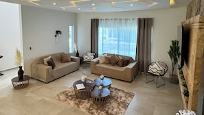 A modern living room with two sofas, a coffee table, and a dining table. - VACATION FAMILY HOME, MODERN HIMALAYA II (Fraccionamiento Lomas de Cocoyoc)