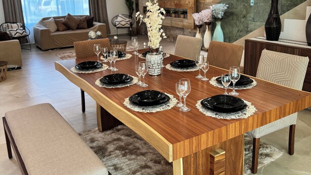 A modern dining room with a wooden table set for six, surrounded by chairs. - VACATION FAMILY HOME, MODERN HIMALAYA II (Fraccionamiento Lomas de Cocoyoc)