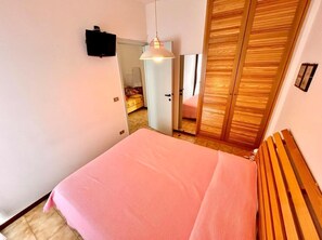 Ein Schlafzimmer mit einem großen Bett, einem Holzkopfende und einem Schrank mit Spiegel.