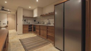 A modern kitchen with wooden cabinets, a stainless steel refrigerator, and a built-in oven. - Luxury penthouse / Heart of Santa Marta (Santa Marta)