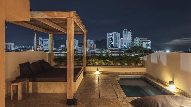 A rooftop terrace with a wooden pergola, a small pool, and a cityscape view at night. - Luxury penthouse / Heart of Santa Marta (Santa Marta)