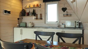 Une cuisine de taille réduite avec des meubles blancs, une fenêtre, un four à micro-ondes, un grille-pain et un évier.