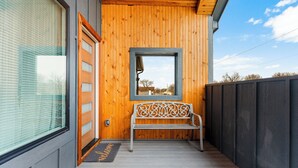A wooden exterior with a bench, a door, and a window.