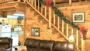 Een houten interieur met een trap versierd met kerstkransen en decoraties.