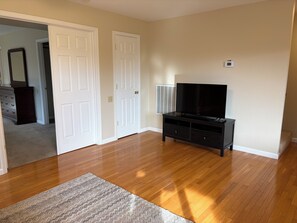 A room with wooden flooring, a TV stand, and a door leading to another room. - Mountain views, 45 minutes to Kirkwood, 30 minutes to Wine country.  (Pioneer)
