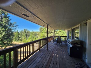 A covered porch with a wooden deck, a barbecue grill, and a table with chairs. - Mountain views, 45 minutes to Kirkwood, 30 minutes to Wine country.  (Pioneer)