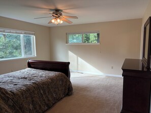 A bedroom with a bed, a ceiling fan, two windows, and a dresser. - Mountain views, 45 minutes to Kirkwood, 30 minutes to Wine country.  (Pioneer)