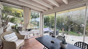 A sunlit patio with a dining table, chairs, and a decorative sailboat model. - Typically Provençal, located in the hills above Les Issambres, 6+1 (LES ISSAMBRES)