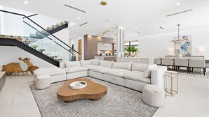 Ein modernes Wohnzimmer mit einem Ecksofa, einem Couchtisch aus Holz und einer Treppe.