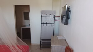 A small, compact room with a bed, a desk, a wardrobe, and a radiator. - Charming room in St Philippe, between the sea and the mountains, close to the GRR2 footpaths. (Saint-Philippe)