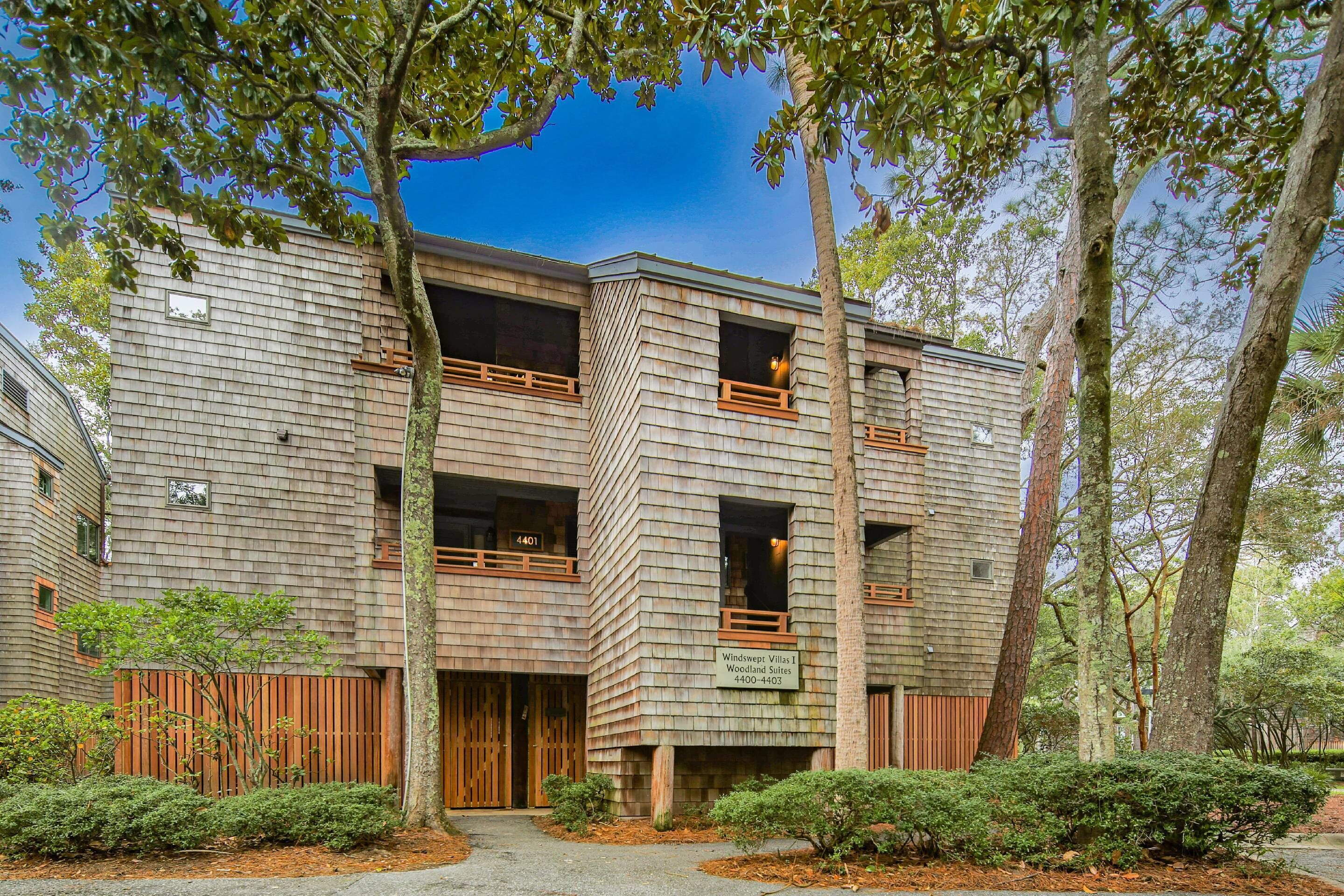 A multi-story building with a wooden facade, balconies, and a sign indicating 'Windy Ridge Villas 1'.